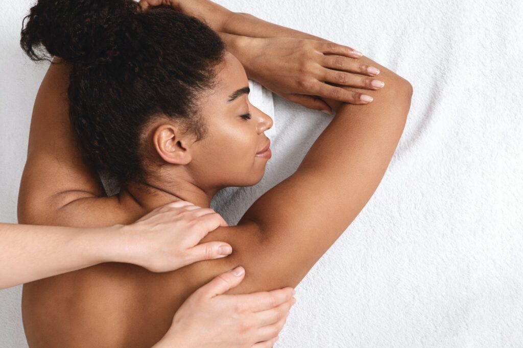 Closeup of black young woman having healing body massage